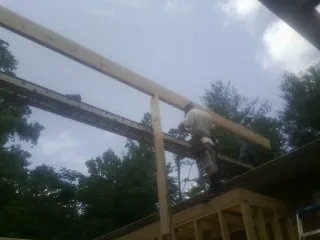 Carpenter setting a ridge beam over a new addition frame — Ice Dam Removal by Roofing Brothers in Torrey