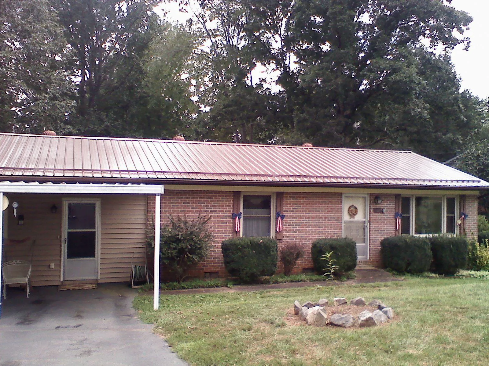 Bronze metal roof and carport on a brick ranch home — Roof Repair work by our crew in Torrey
